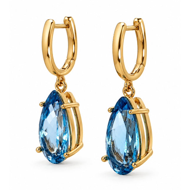 Side view of a pair of gold-plated sterling silver pear shape blue topaz drop earrings. 