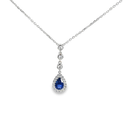 Teardrop shaped pendant with blue gemstone and diamonds on a white background